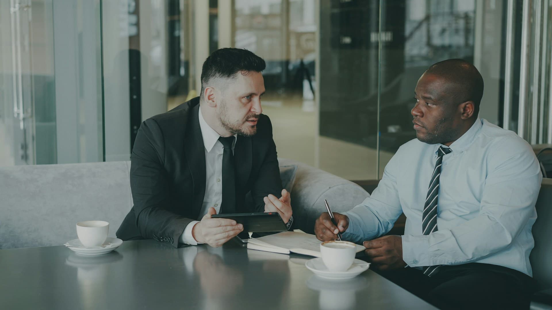 Two people in a focused coaching conversation at a table