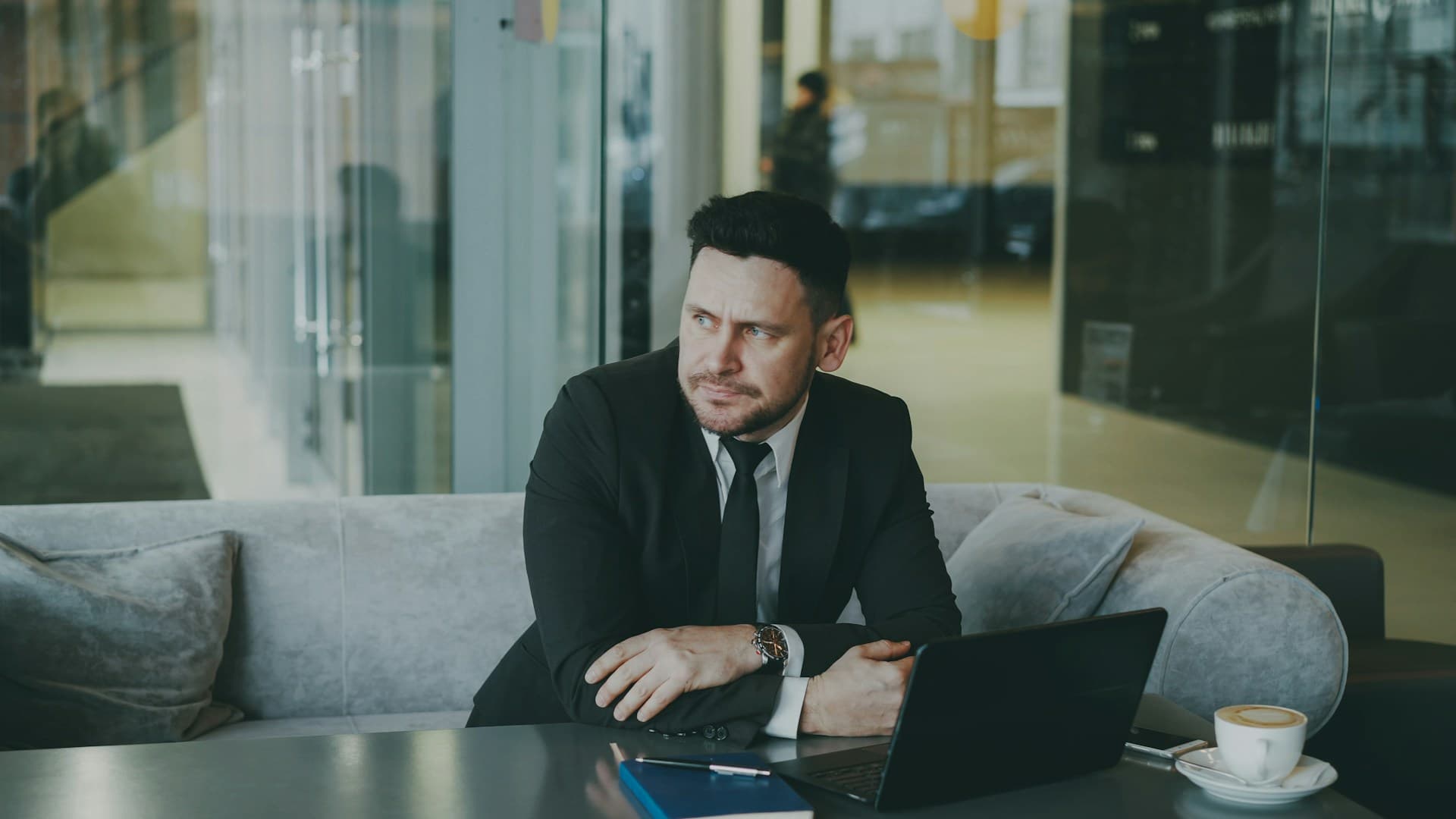 A business owner sitting pensively at a laptop in a modern office